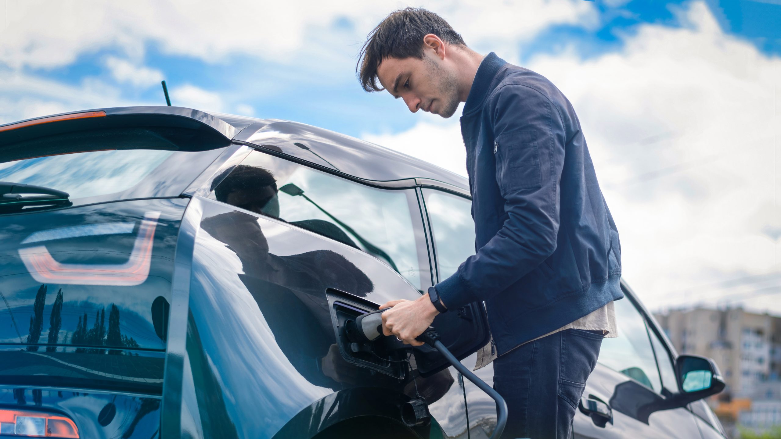 Man charging his electric car at charge station